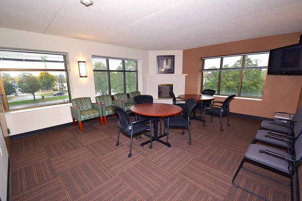 a community room with a table and chairs and a fireplace