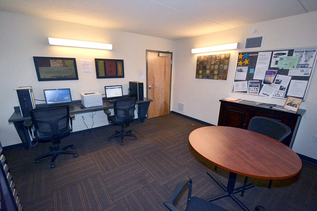an office with two computers and a round table