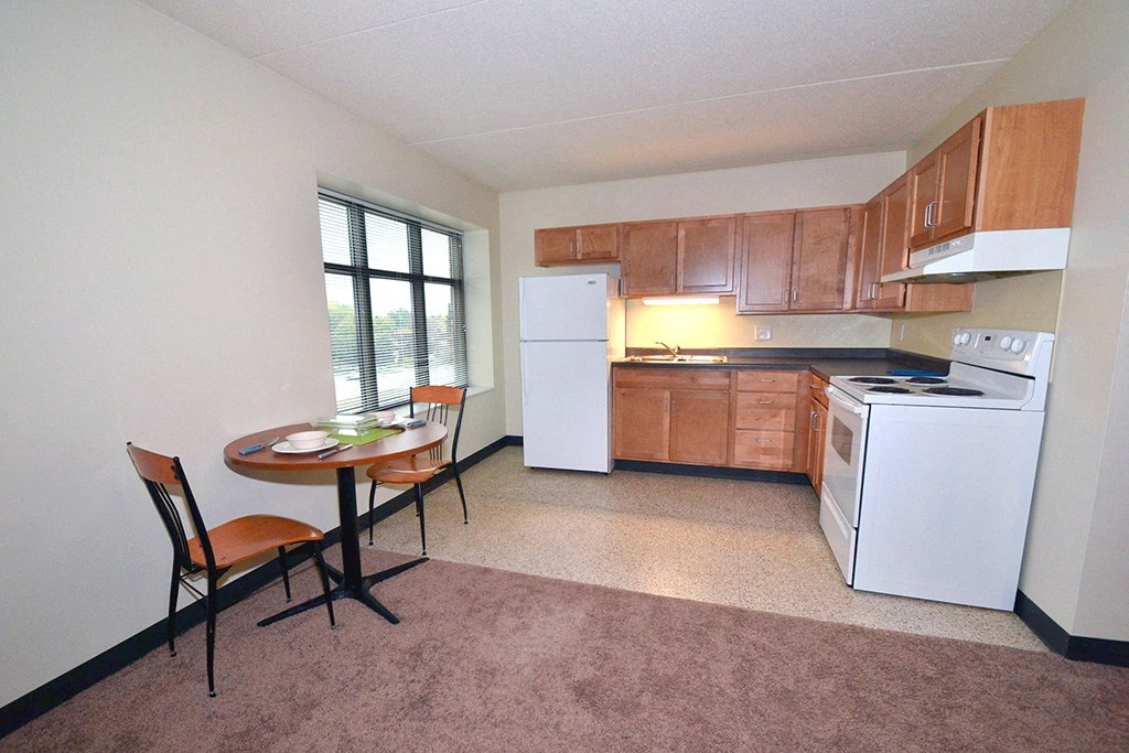 a kitchen with a small table and a refrigerator