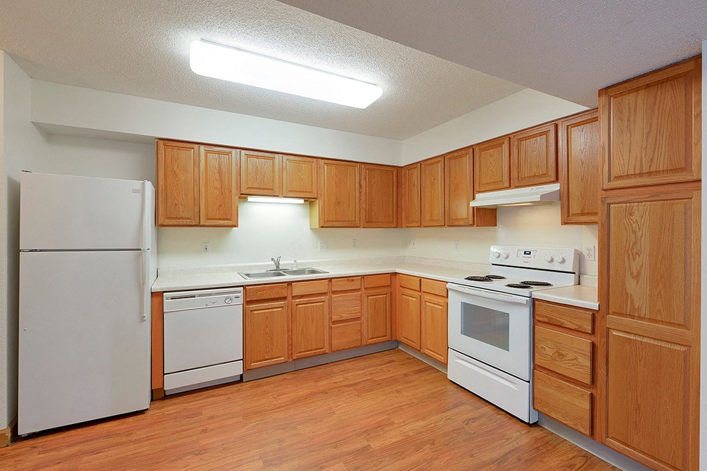 a kitchen with white appliances and wooden cabinets