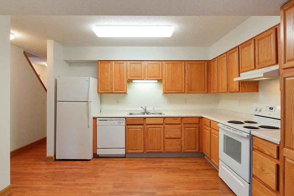 a kitchen with white appliances and wooden cabinets