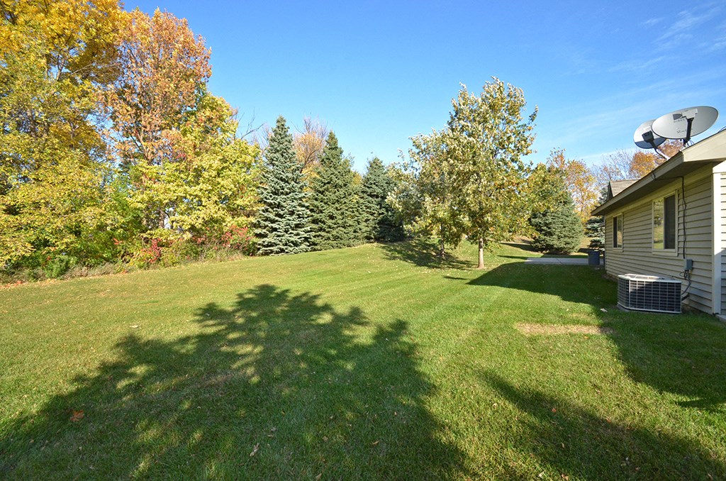 a yard with a house and a basketball hoop