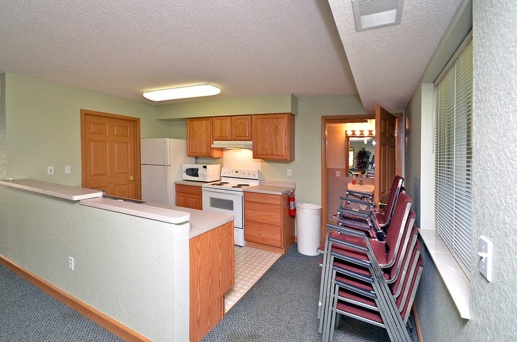 a kitchen with a row of chairs   and a kitchen table
