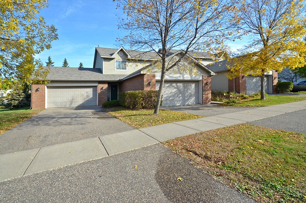 a house with two garage doors and a sidewalk