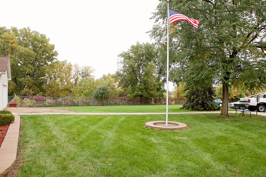 a flag pole in the middle of a lawn
