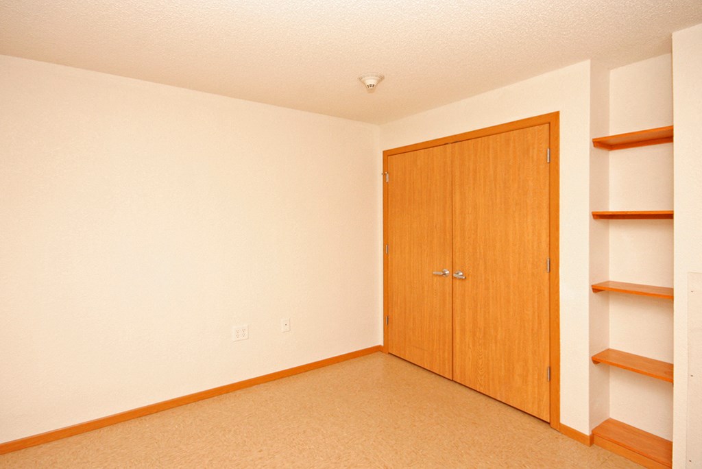 an empty room with a closet and shelves
