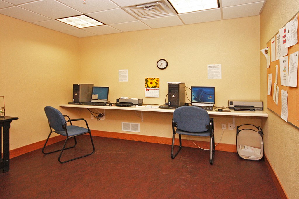 a computer room with two chairs and a desk with computers