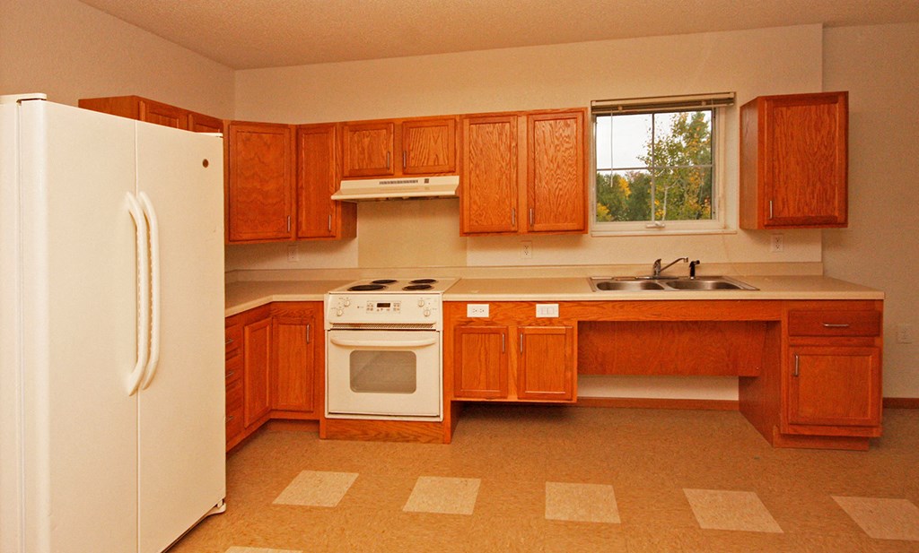 a kitchen with wooden cabinets and a white refrigerator