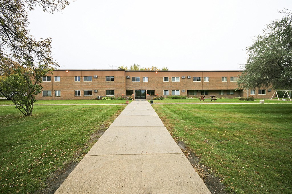 a large brick building with a sidewalk in front of it