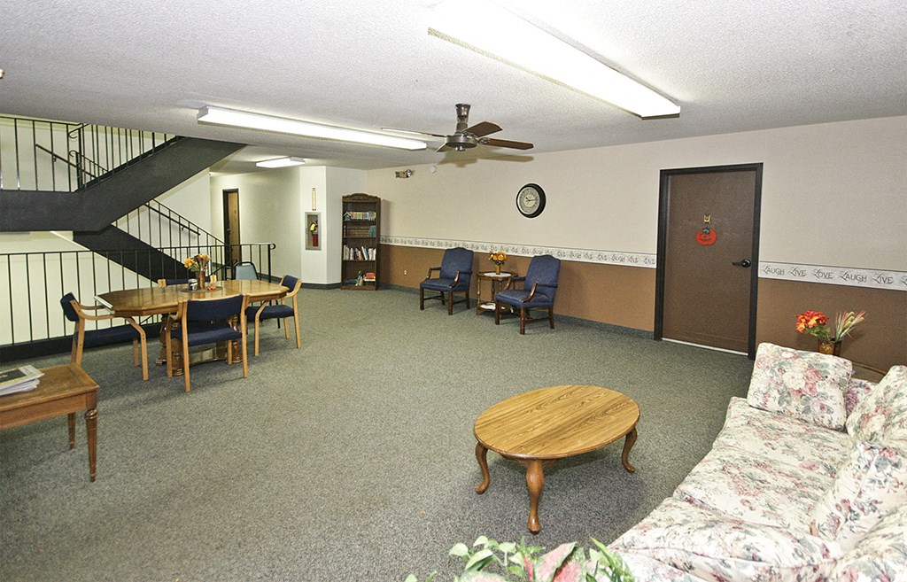 an empty living room with furniture and a stairwell