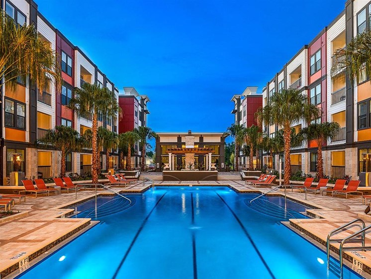 Revitalizing Resort Style Swimming Pool with Relaxation Space and Seating Area at EOS Apartments, Orlando, FL 32826