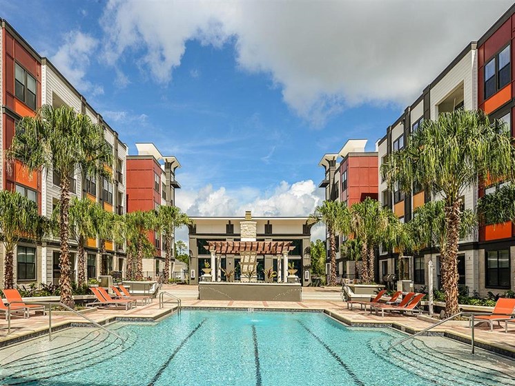 Revitalizing Resort Style Swimming Pool with Relaxation Space and Seating Area at EOS Apartments, Orlando, FL 32826