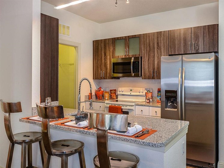 Open Floor Plan Kitchen with Wood Plank Vinyl Flooring (in Select Units) and Chef's Table-inspired Islands at EOS Apartments, Orlando, FL 32826