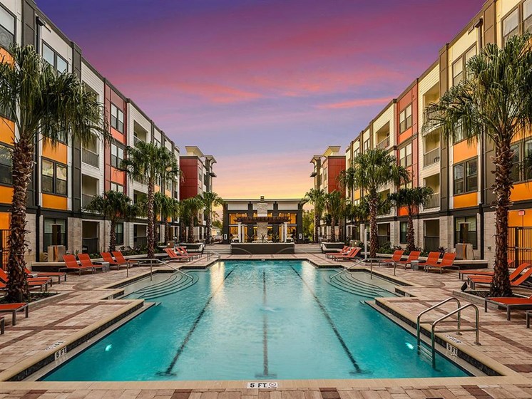 Revitalizing Resort Style Swimming Pool with Relaxation Space and Seating Area at EOS Apartments, Orlando, FL 32826