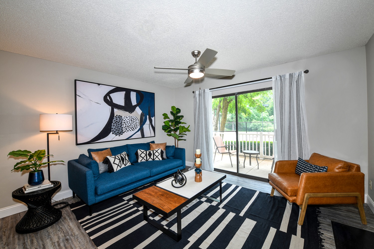 a living room with a blue couch and a ceiling fan