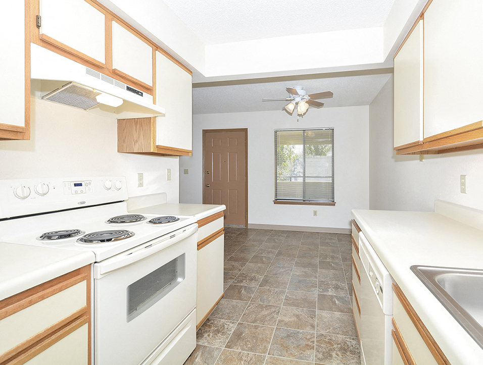 Galley Kitchen with White Appliances and Tile Style Flooring