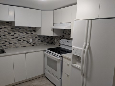 an all white kitchen with white appliances and white cabinets