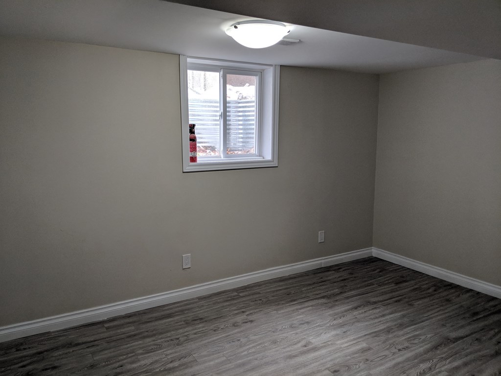 an empty room with wood floors and a window