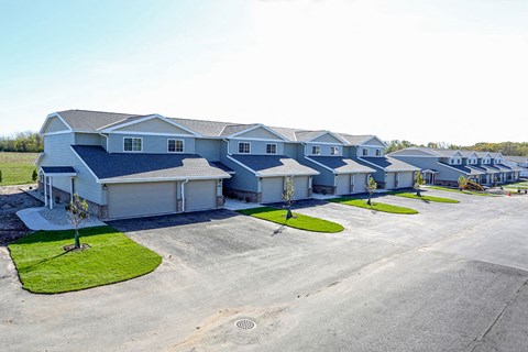 a row of blue and white houses next to a parking lot