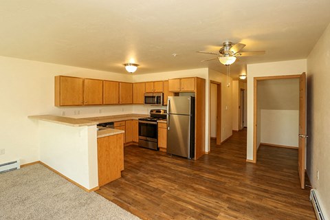 a kitchen with wooden cabinets and a stainless steel refrigerator