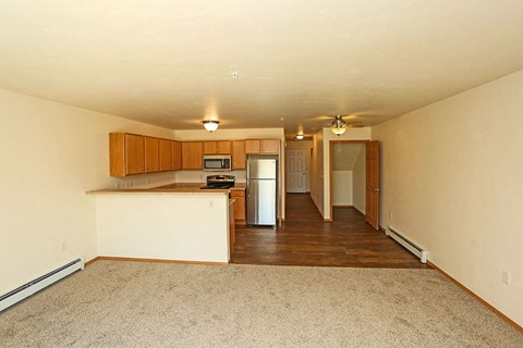 an empty living room with a kitchen and a