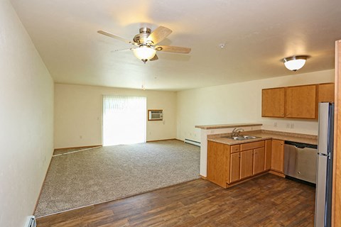 an empty kitchen and living room with a ceiling fan