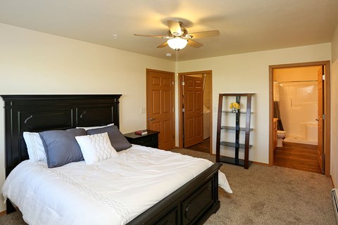 a bedroom with a large bed and a ceiling fan