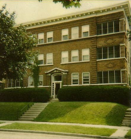a large brick building with a lawn in front of it