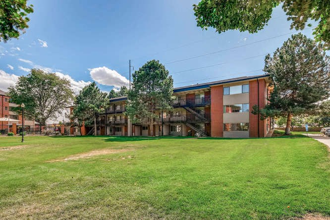 a large green lawn in front of an apartment building