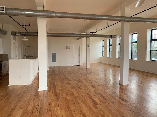 an empty living room with a wood floor
