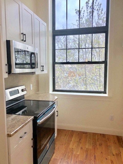a kitchen with a stove microwave and a window