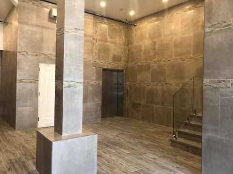 the lobby of a building with a pillar and stairs