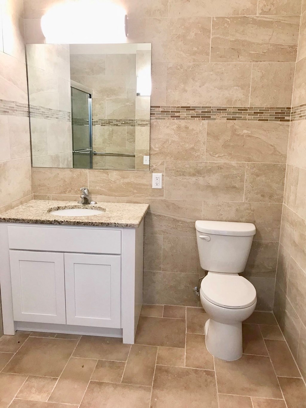 a bathroom with a toilet and a sink and a mirror