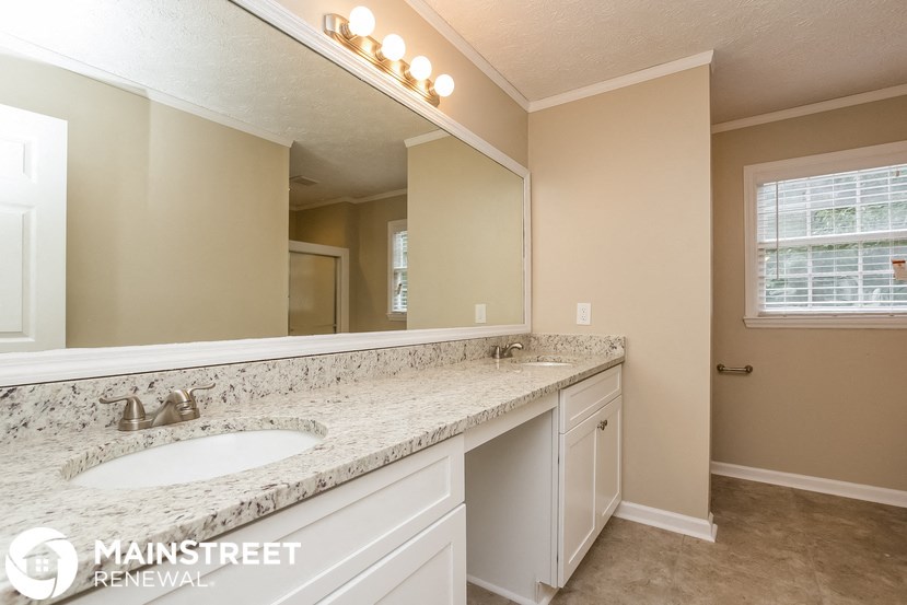 the master bathroom has a large mirror and a large sink