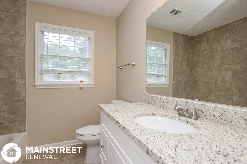 a bathroom with a sink and a toilet and a mirror