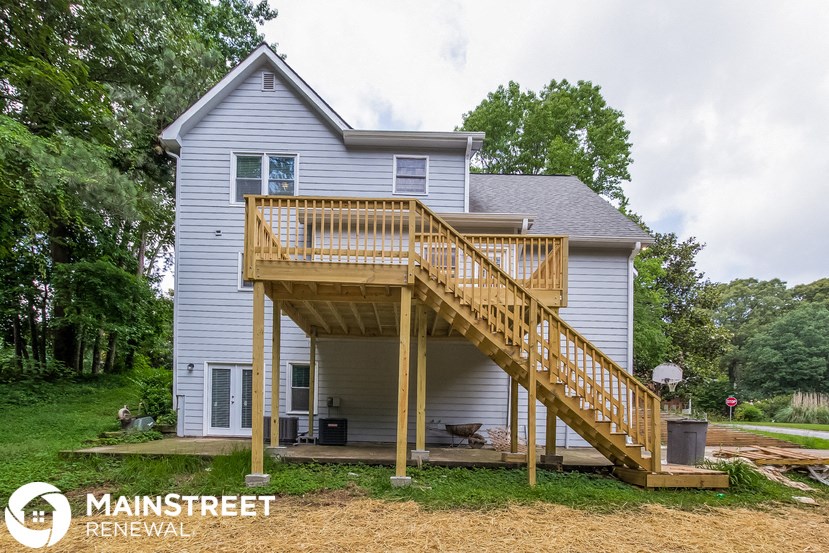 a house with a wooden deck on top of a yard