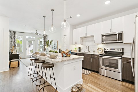 A modern kitchen with white cabinets and a center island.