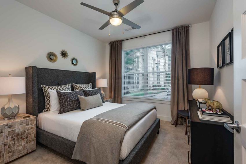 a bedroom with a large bed and a ceiling fan