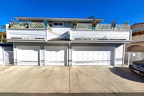 the front of a garage with white doors