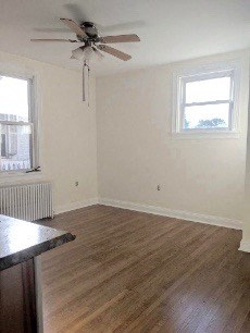 A room with a ceiling fan and a window.