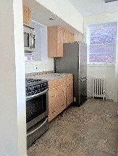 A kitchen with a black refrigerator, stove, and oven.