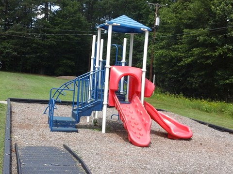 a playground with a blue and red swing set