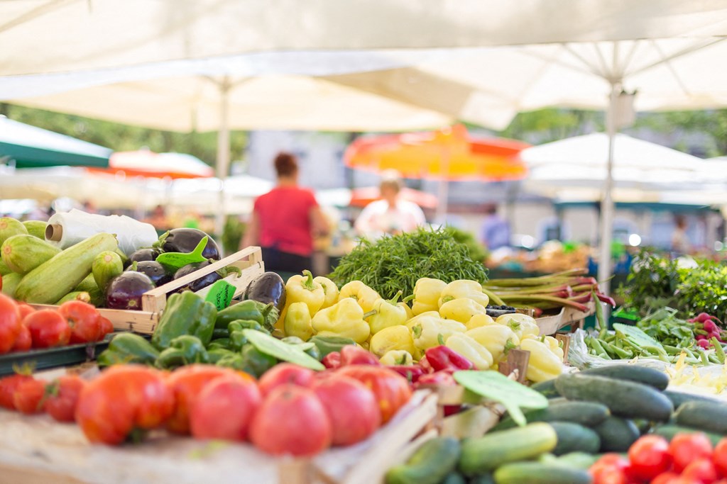 A market scene with a variety of vegetables on display.