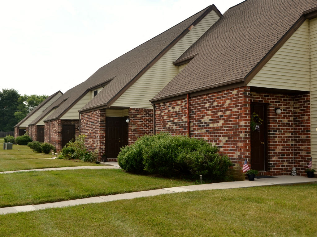 A series of houses with brick walls and brown roofs.