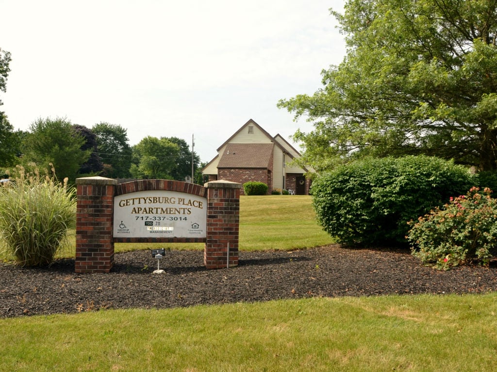 A sign for Gettysburg Place Apartments is in front of a building.