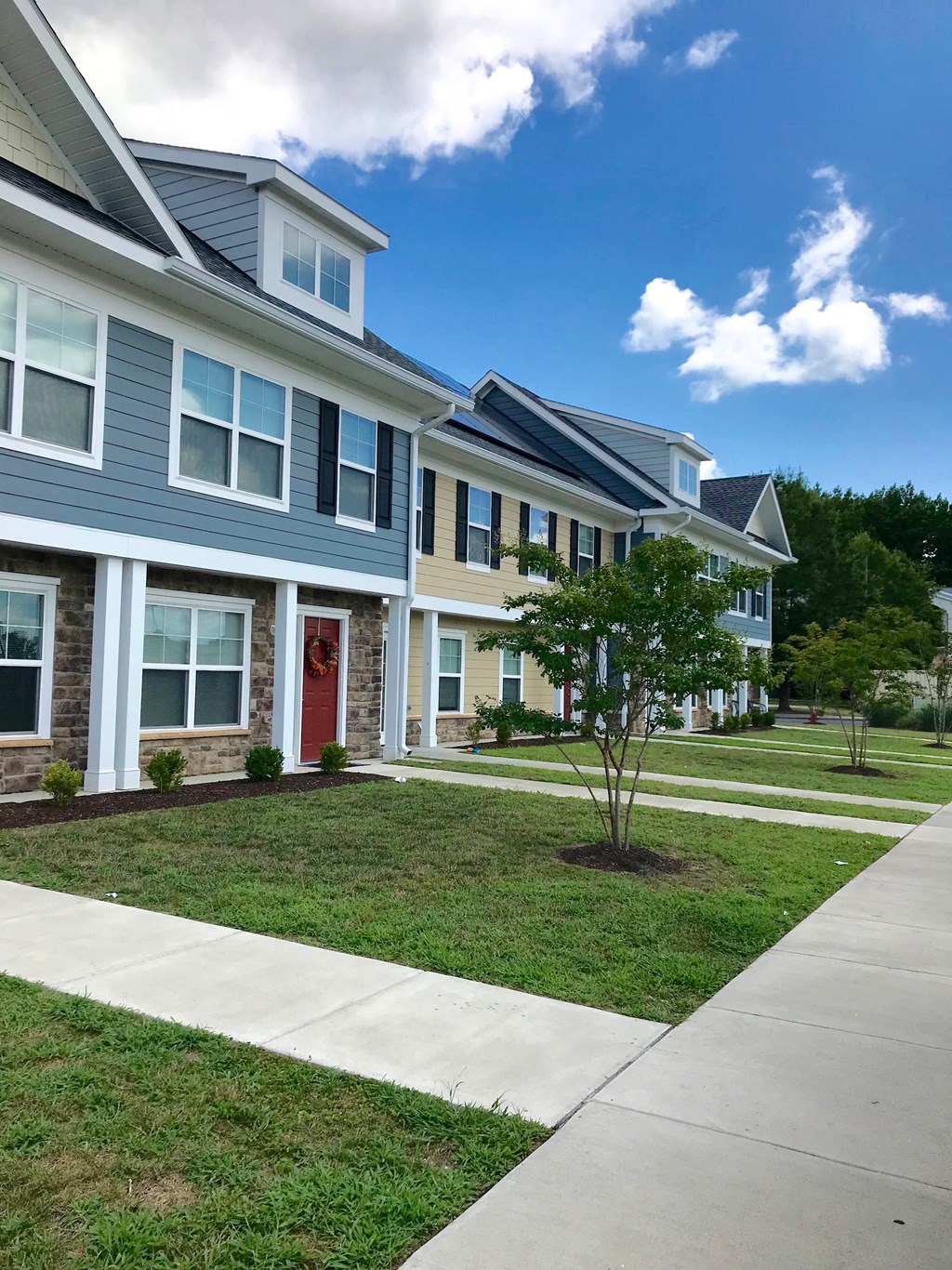 a row of houses with a sidewalk in front of them