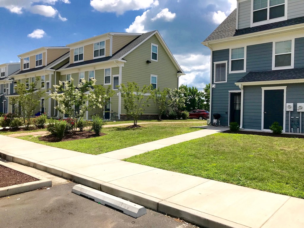 a sidewalk in front of a row of houses