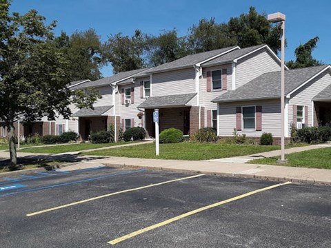 Apartment building with a parking lot in front.