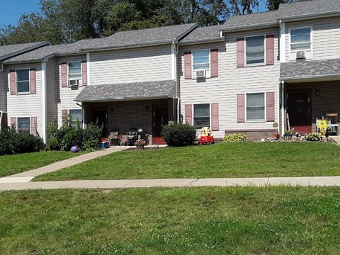 Apartment building with a red car parked in the driveway.