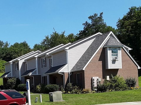 A house with a red car parked in front.